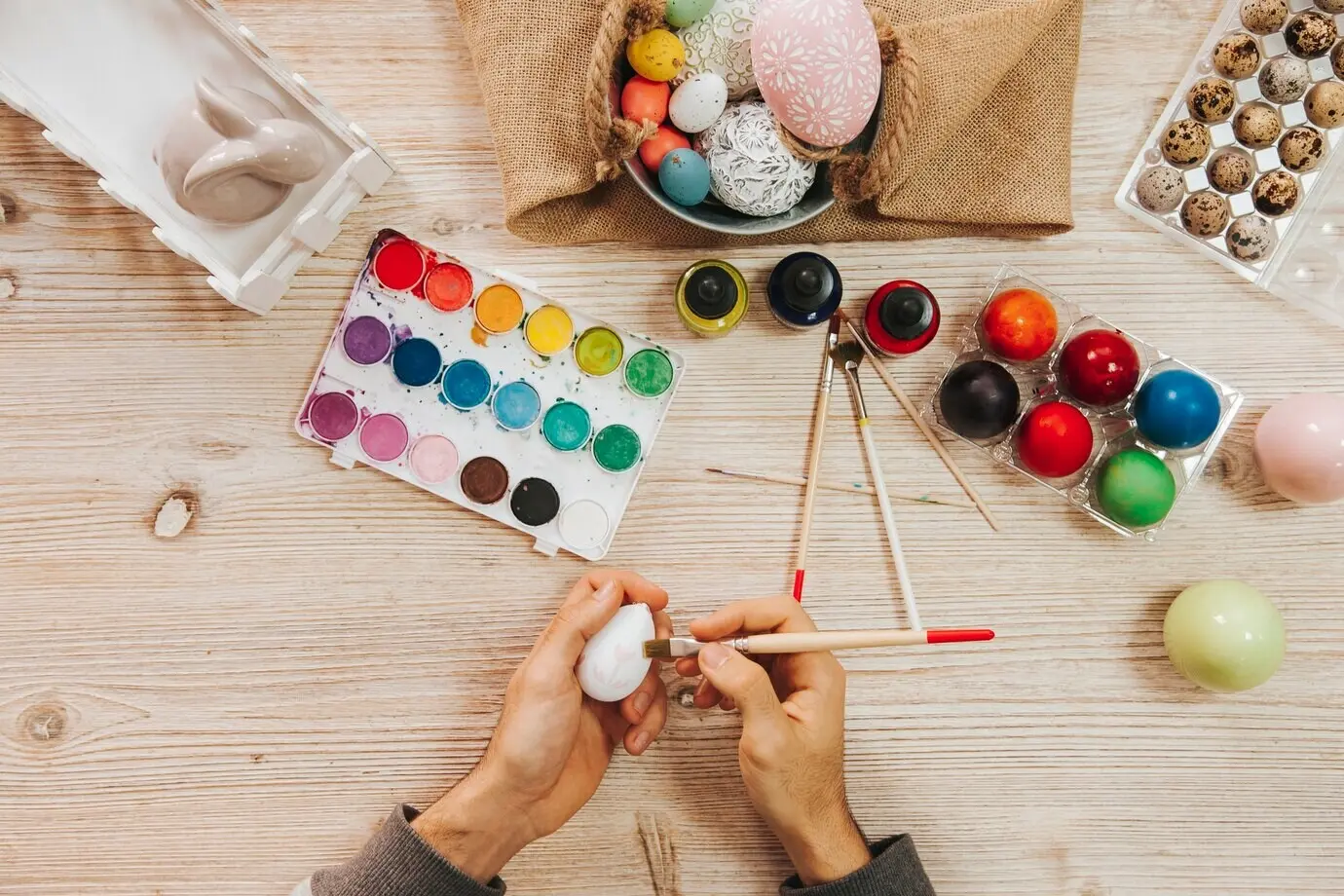 Bildausschnitt einer Person, die Ostereier dekoriert.